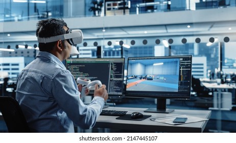 Automotive Engineer Using A VR Software To Work On Electric Motor And Vehicle Platform In Interactive Environment In A Factory Office. Industrial Engineer Using Headset And Controllers.