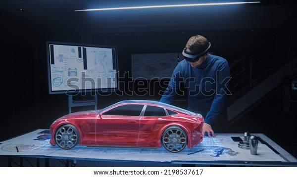 Automotive Engineer Wearing Virtual Reality\
Headset Working on 3D Electric Car Design, Using Gestures in\
Augmented Reality and Designs and Manipulates Graphical Parts,\
Picks Body for Chassis,\
Engine