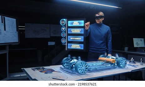 Automotive Engineer Wearing VR Headset Working On 3D Electric Car Design, Using Gestures In Augmented Reality He Designs And Manipulates Graphical Parts, Picks Body For The Chassis And Engine