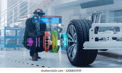 Automotive Engineer Working on Electric Car Chassis Platform, Using Augmented Reality Headset with 3D VFX Software for Development of Regenerative Braking System on a Transport Vehicle. - Shutterstock ID 2200855939