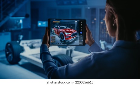 Automotive Engineer Working on Electric Car Chassis Platform, Using Tablet Computer with Augmented Reality 3D Software. Innovative Facility: Vehicle Frame with Wheels Becomes a VFX Virtual Model. - Powered by Shutterstock