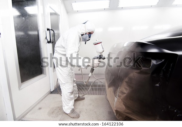 Automotive\
engineer working on painting a black\
car