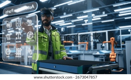 Automotive Factory Engineer Using Augmented Reality Headset in a Modern Facility with Automated Robotic Arms on an Assembly Plant.