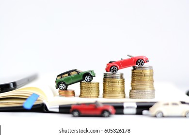 Automotive Industry Evolution Concept With Colored Toy Cars On Pile Of Coins