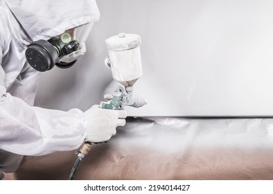 Automotive Industry Painter Worker Wearing Breathing Safety Mask and Uniform Painting Vehicle Body with a White Paint. Transportation Theme. - Powered by Shutterstock