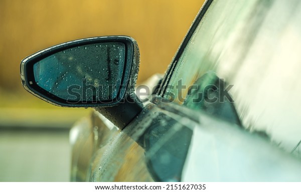 Automotive Maintenance Theme. Clean and\
Still Wet Modern Vehicle Mirror After Car Wash\
Cleaning