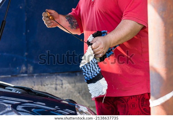 Automotive\
mechanic checking the level of engine oil. Vehicle maintenance in\
the garage in Bucharest, Romania,\
2022