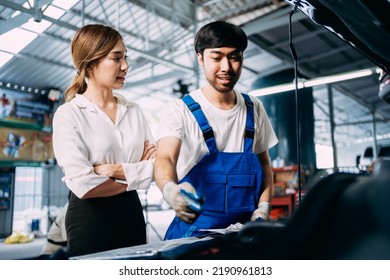 Automotive Mechanic Repairman Talking To A Female Customer At The Garage, Check The Mileage Of The Car, Oil Change, Auto Repair Service Concept.