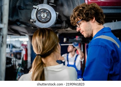 Automotive Mechanic Repairman Talking To Female Customer At The Garage, Check The Mileage Of The Car, Oil Change, Auto Repair Service Concept.