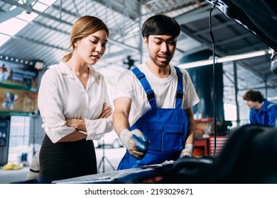 Automotive Mechanic Repairman Talking To A Female Customer At The Garage, Check The Mileage Of The Car, Oil Change, Auto Repair Service Concept.