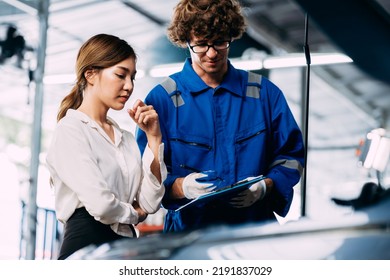 Automotive Mechanic Repairman Talking And Show The Car Checking List Before Fix To Female Customer At The Garage, Check The Mileage Of The Car, Oil Change, Auto Repair Service Concept.
