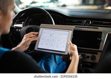 Automotive Mechanic Running Diagnostics Software On Tablet. Unrecognizable Vehicle Service Manager Worker Work In Mechanics Garage, Check And Maintenance To Repair The Engine Car In Workshop.