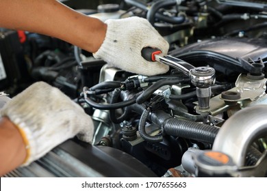 Automotive mechanic working in garage. Repair service. Mechanic working on a diesel engine, close up. Technician hands of car mechanic in doing auto repair service and maintenance worker repairing.