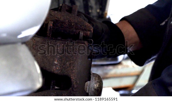Automotive mechanics repair the shock absorber\
on the vehicle.