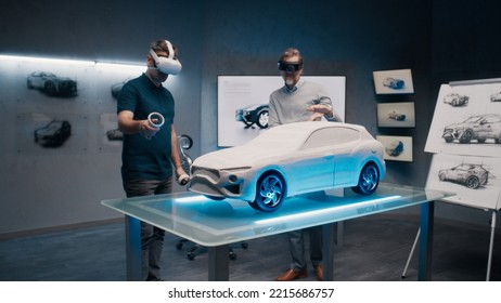Automotive professional engineers with VR headset and joysticks talk about vehicle production while standing infront of a prototypecar model in a high tech office. Car design analysis and improvement. - Shutterstock ID 2215686757