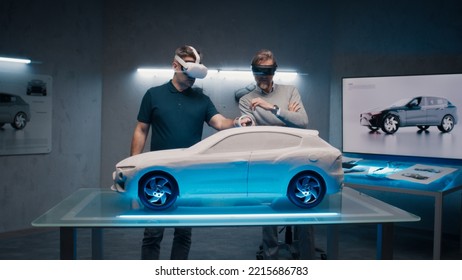 Automotive Professional Engineers With VR Headset And Joysticks Talk About Vehicle Production While Standing Infront Of A Prototypecar Model In A High Tech Office. Car Design Analysis And Improvement.