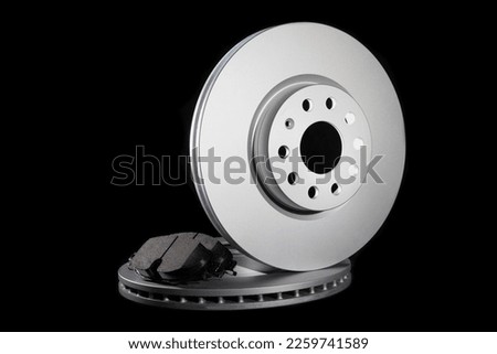 Automotive spare parts from the braking system. Brake pads and discs on a black background