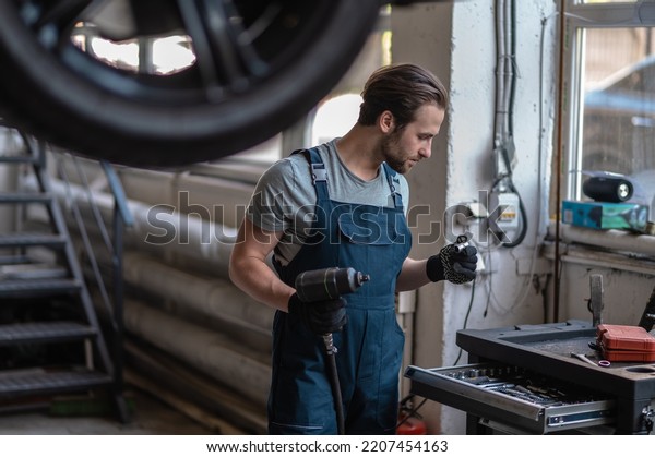 Automotive\
technician preparing for work in his\
workshop