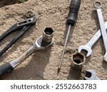 Automotive tools: ratchet, captive horn wrenches, screwdrivers, pliers, tongs on a concrete surface background. Garage and workshop. Automotive mechanics, engineering, manufacturing, industry