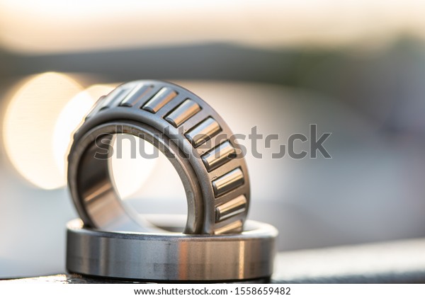 Automotive wheel tapered roller bearing on road\
background with\
bokeh