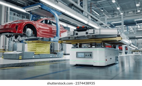 Autonomous AGV Transports Batteries on EV Production Line on Advanced Bright Smart Factory. Performance Electric Car Manufacturing. Car Batteries being Attached to Electric Vehicles on Assembly line - Powered by Shutterstock