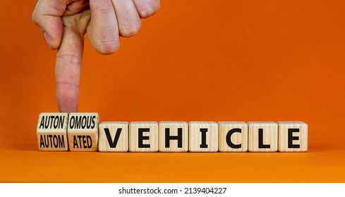 Autonomous Or Automated Vehicle Symbol. Businessman Turn Cubes Changes Words Automated Vehicle To Autonomous Vehicle. Orange Background. Business Autonomous Or Automated Vehicle Concept, Copy Space.