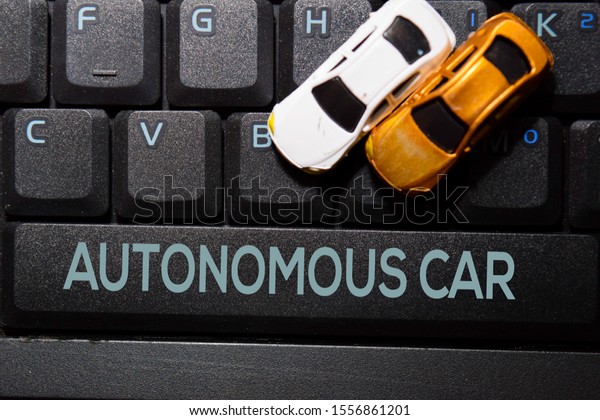 Autonomous Car write on keyboard and toy car\
isolated on laptop\
background