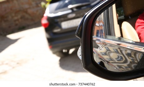 Autonomous cars on a road with visible connection. Blind Spot Monitoring system warning light icon in side view mirror of a modern vehicle. Car system