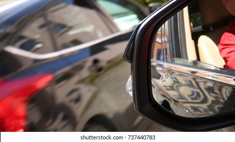 Autonomous cars on a road with visible connection. Blind Spot Monitoring system warning light icon in side view mirror of a modern vehicle. Car system
