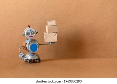 An autonomous robot courier holds in his hand a package packed in a cardboard box. Brown background with free space for text.