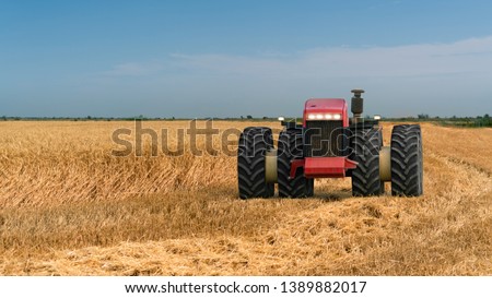 Autonomous tractor working in the field. Smart farming and digital transformation in agriculture