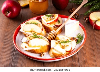 Autumn Apple Brie Crostini with Walnuts and Honey, Fall dinner, Thanksgiving party appetizers idea. Small sandwiches with red apple slices, brie cheese and sweet honey drizzles - Powered by Shutterstock