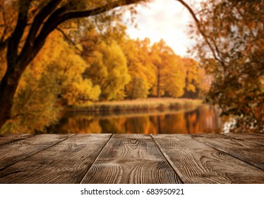 Autumn background, close up of old empty wooden table over the lake with copy space - Powered by Shutterstock