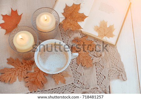autumn background. Cup of coffee, candles, book and autumnal leaves on table. cozy still life. home comfort in fall season. relax time. top view