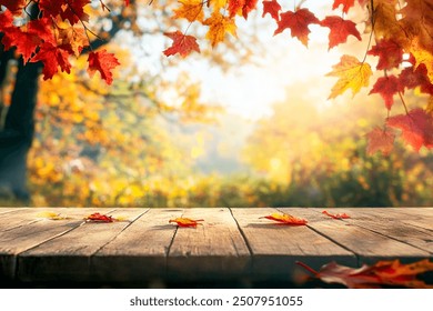 Autumn background with empty wooden table, red and yellow leaves and blurred background