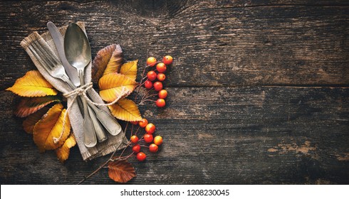 Autumn Background From Fallen Leaves And Fruits With Vintage Place Setting On Old Wooden Table. Thanksgiving Day Concept