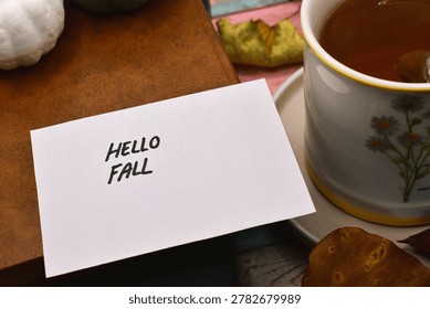 autumn background - hello fall write on card with rustical wooden background 