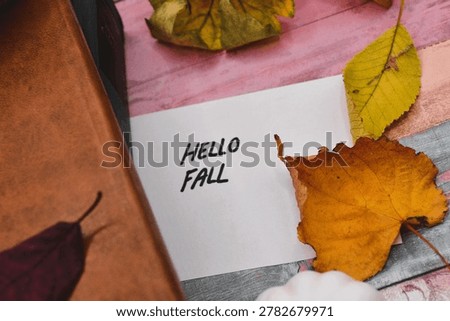 autumn background - hello fall write on card with rustical wooden background 