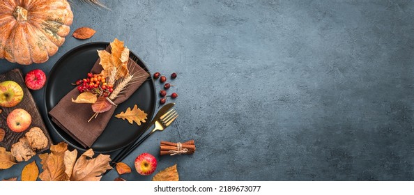 Autumn background with a plate with cutlery on a graphite background. Top view, copy space - Shutterstock ID 2189673077