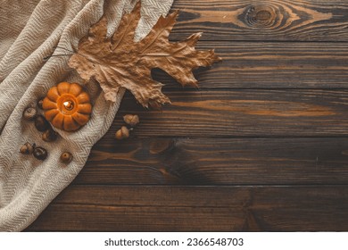 Autumn background top view, candle and leaves on wooden background. - Shutterstock ID 2366548703
