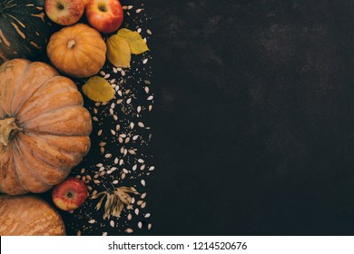 Autumn background with yellow leaves, red apples and pumpkins. Border of fall harvest on aged wood with copy space. Mockup for seasonal offers and autumn food, Top view with copy space. Toned image.
