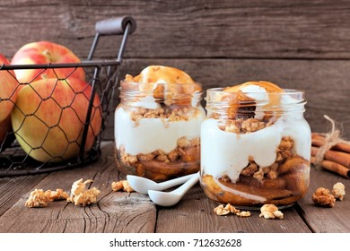 Autumn Baked Apple Parfaits With Caramel Sauce In Mason Jars, Scene On A Rustic Wood Background