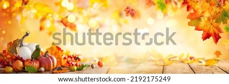 Autumn banner with fallen maple leaves and pumpkins on wooden vintage table. Autumn concept with red-yellow leaves background. Thanksgiving pumpkins.