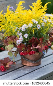 Autumn Bouquet Of Flowers With Viburnum Berries In A Copper Planter Outdoors