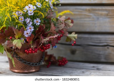 Autumn Bouquet Of Flowers With Viburnum Berries In A Copper Planter Outdoors