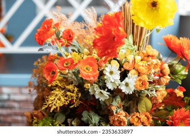 Autumn bouquet of yellow and orange flowers. Beautiful floral arrangement with fall orange and red flowers and berries, closeup. Cozy Interior fall decor with Autumn composition plants at home.  - Powered by Shutterstock