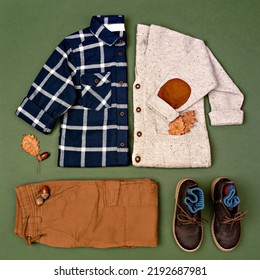 Autumn boy outfit on green background. Little Boy's Autumn Fashion. Kids sweater, shirt, pants and boots arranged with acorns and oak leaves. Autumn or Thanksgiving day mood. Flat lay, top view. - Shutterstock ID 2192687981