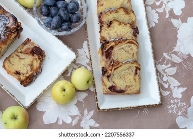 Autumn braided bread cake with apples and plums. Sliced apple buns with plums on wooden board. Bread texture of home baked sweet bread cake with fruits. Slices of bread roll, plums, and apples.  - Shutterstock ID 2207556337