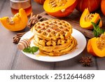 Autumn breakfast dessert, pumpkin waffle. Stack of homemade belgian pumpkin waffles with honey and spices, copy space