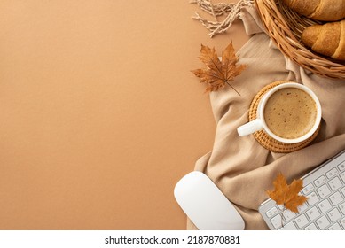 Autumn business concept. Top view photo of cup of coffee rattan placemat wicker tray with croissants computer mouse keyboard yellow maple leaves and scarf on isolated beige background with copyspace